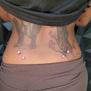 Back surface piercing with matching clear gems at Lethal Ink Tattoo Pattaya. Back surface piercing with matching clear gem surgical steel jewelry at Lethal Ink Tattoo Pattaya (2026)