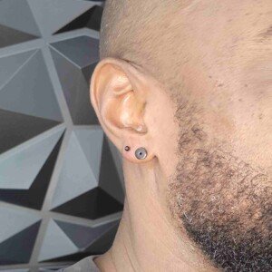 Ear lobe single ring piercing with black surgical steel stud on left ear at Lethal Ink Tattoo Pattaya. Ear lobe single ring piercing with black surgical steel stud on left ear at Lethal Ink Tattoo Pattaya (2026)