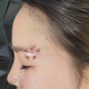 Eyebrow banana piercing with star ball end on left side at Lethal Ink Tattoo Pattaya. Eyebrow second ring banana piercing with star ball end on left side using surgical steel at Lethal Ink Tattoo Pattaya (2026)