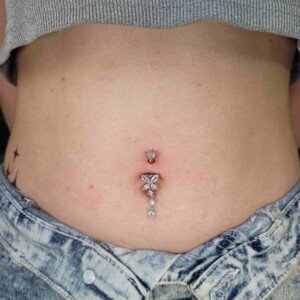 Navel belly button piercing with butterfly gem at Lethal Ink Tattoo Pattaya. Navel belly button piercing with butterfly clear gem surgical steel banana bar at Lethal Ink Tattoo Pattaya (2026)