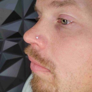 Nostril piercing with clear gem stud on left side at Lethal Ink Tattoo Pattaya. Nostril single ring piercing with clear gem surgical steel stud on left side at Lethal Ink Tattoo Pattaya (2026)